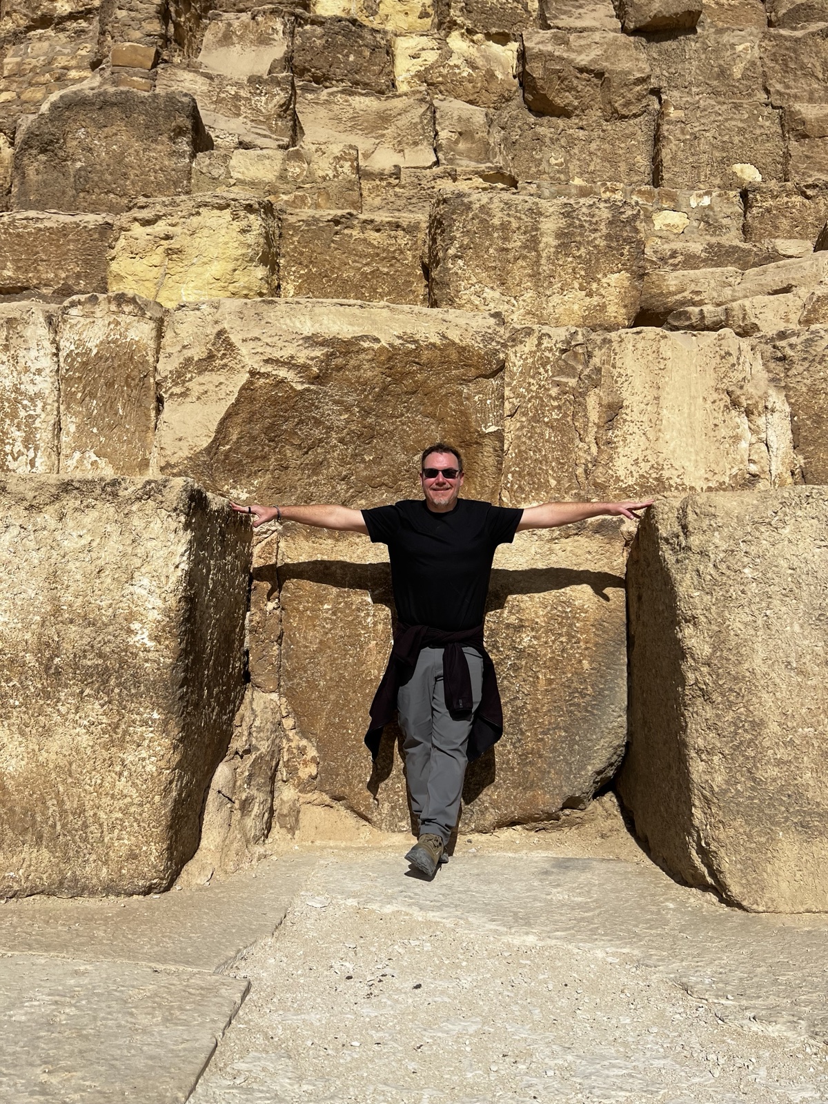 Grant Eckhart standing against a stone wall.